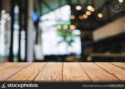 empty blank wooden table in front of blurred montage cafe house background