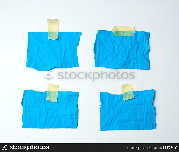 empty blue crumpled pieces of paper glued with duct tape on a white background