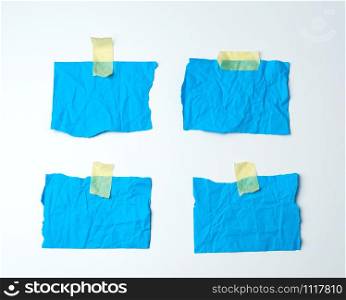 empty blue crumpled pieces of paper glued with duct tape on a white background