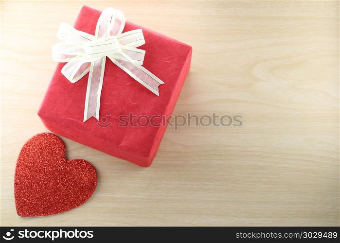 Empty Book and red gift box place near heart shape on the wooden. Empty Book and red gift box place near heart shape on the wooden floor in concept of Christmas and Valentine day.