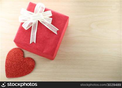 Empty Book and red gift box place near heart shape on the wooden. Empty Book and red gift box place near heart shape on the wooden floor in concept of Christmas and Valentine day.