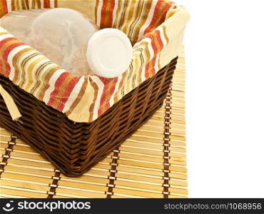 Empty Bottle In Basket At Bamboo Mat Against The White Background. Bottle In Basket