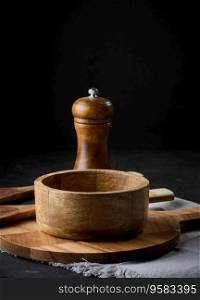 Empty bowl and wooden spoons on a black table