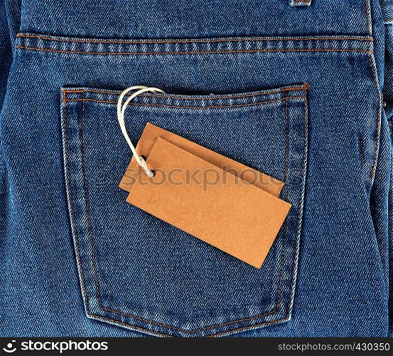 empty brown paper tag on a rope tied to blue jeans, full frame