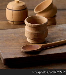 empty brown plates and wooden spoon on a wooden table, top view