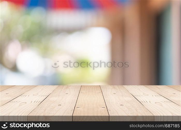 Empty brown wood table top on blur background at shopping mall, copy space for montage you product