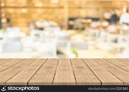 Empty brown wood table top on blurred background at coffee shop, copy space for montage your product