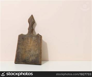 empty brown wooden kitchen board on a white table, utensils