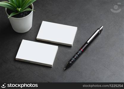 Empty business cards and pencil. Mockup for branding identity on dark stone background. Empty business cards