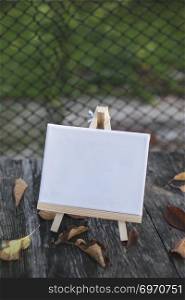 Empty canvas for painting in the garden. Many autumn leaves