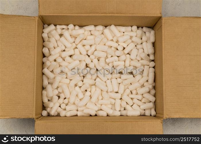 Empty cardboard box with styrofoam filler for safe packaging. Top view. Filler for packaging