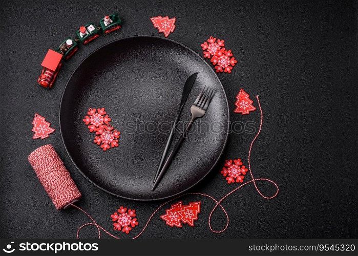 Empty ceramic black plate with christmas decoration elements on holiday textured concrete background