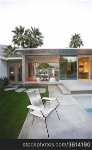 Empty chair on paved poolside area of Palm Springs home