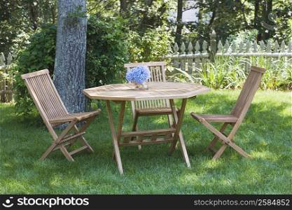Empty chairs and a table in a lawn