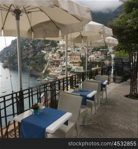 Empty chairs and tables with a patio umbrellas on terrace, Positano, Amalfi Coast, Salerno, Campania, Italy