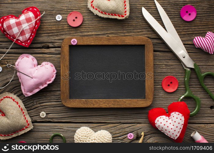 empty chalkboard surrounded by haberdashery accessories