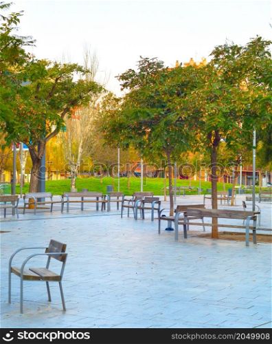Empty city park, trees and benches, no people. Barcelona, Spain