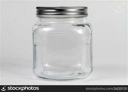 Empty clear glass jar with screw lid.