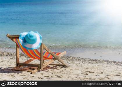 Empty colorful beach chairs and sun hat on the beach, clear, blue sky.. Beach chair on the beach.