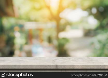 Empty concrete table and defocused bokeh and blur background of garden trees with sunlight. product display template.