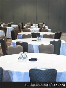 Empty conference room with many tables with white cloths