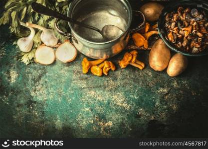 Empty cooking pot with spoon ,forest mushrooms and cooking ingredients for soup or stew on dark rustic background, top view, border
