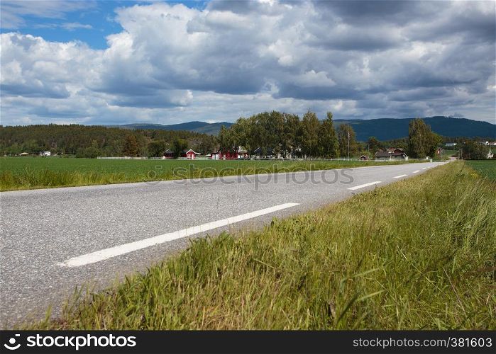 empty country road with the houses on a hills at Norway