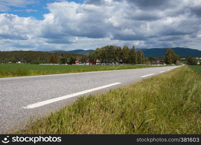 empty country road with the houses on a hills at Norway