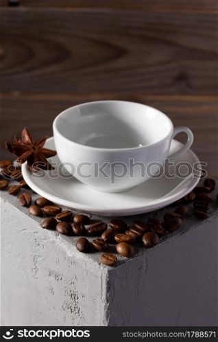 Empty cup of coffee and beans on concrete grey cube as background texture. Abstract concept of break coffee time