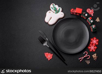 Empty dark ceramic plate with elements of Christmas decorations on a dark concrete background