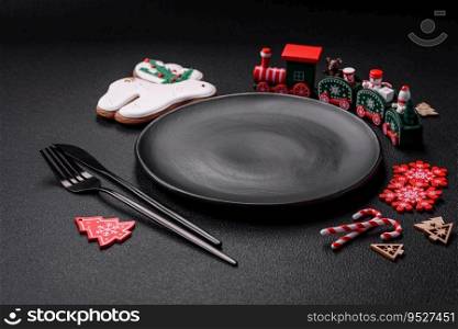Empty dark ceramic plate with elements of Christmas decorations on a dark concrete background