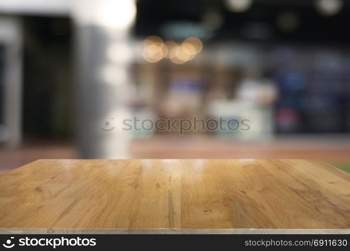 Empty dark wooden table in front of abstract blurred background of cafe and coffee shop interior. can be used for display or montage your products