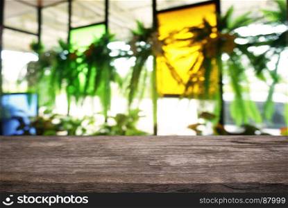 Empty dark wooden table in front of abstract blurred background of cafe and coffee shop interior. can be used for display or montage your products