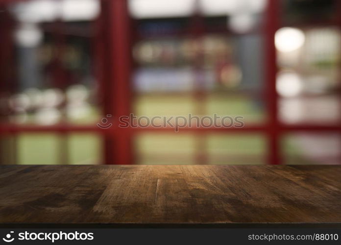 Empty dark wooden table in front of abstract blurred background of cafe and coffee shop interior. can be used for display or montage your products