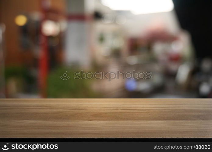 Empty dark wooden table in front of abstract blurred background of cafe and coffee shop interior. can be used for display or montage your products