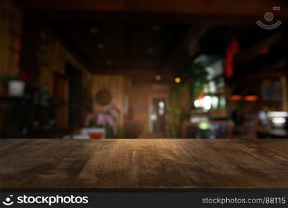Empty dark wooden table in front of abstract blurred background of cafe and coffee shop interior. can be used for display or montage your products