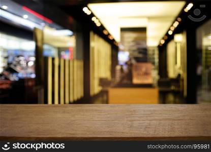 Empty dark wooden table in front of abstract blurred background of cafe and coffee shop interior. can be used for display or montage your products.