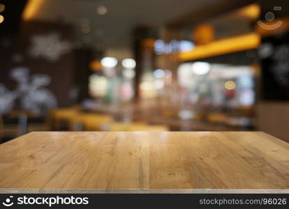 Empty dark wooden table in front of abstract blurred background of cafe and coffee shop interior. can be used for display or montage your products