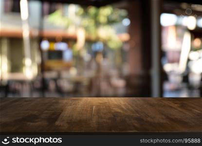 Empty dark wooden table in front of abstract blurred background of coffee shop . can be used for display or montage your products.Mock up for display of product.
