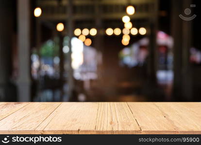 Empty dark wooden table in front of abstract blurred background of coffee shop . can be used for display or montage your products.Mock up for display of product.