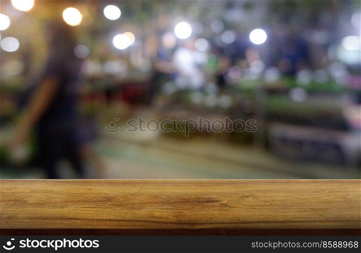 Empty dark wooden table in front of abstract blurred background of restaurant, shopping mall and people walking. can be used for display or montage your products - Image