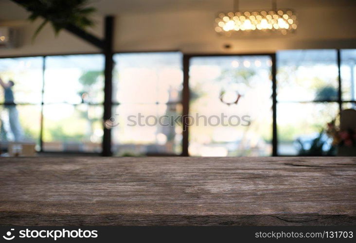 Empty dark wooden table in front of abstract blurred bokeh background of restaurant . can be used for display or montage your products.Mock up for space