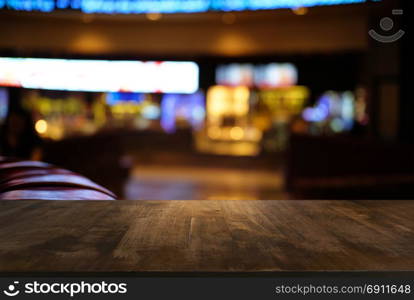 Empty dark wooden table in front of abstract blurred bokeh background of restaurant . can be used for display or montage your products.Mock up for space