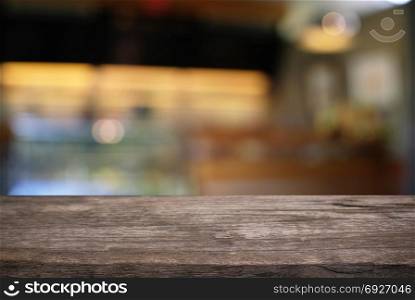 Empty dark wooden table in front of abstract blurred bokeh background of restaurant. can be used for display or montage your products.Mock up for space
