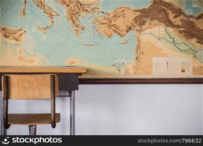 Empty desks at school classroom with world map close-up. Empty desks at school classroom with world map.