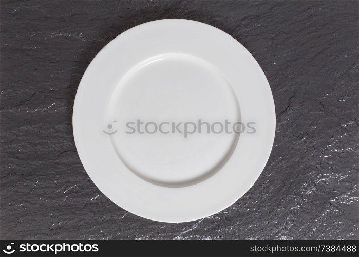 Empty dish on a slate in bird&rsquo;s eye view.. Empty dish on a slate in bird&rsquo;s eye view
