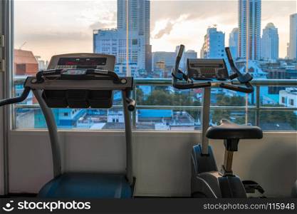 empty exercise equipment in the gym with a nice view of the city