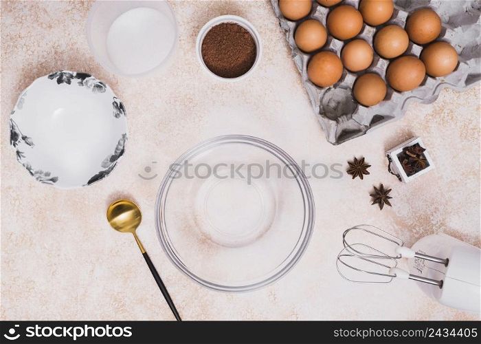empty glass bowl plate flour cocoa powder eggs carton star anise electric mixer kitchen counter