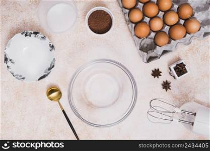 empty glass bowl plate flour cocoa powder eggs carton star anise electric mixer kitchen counter