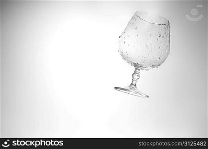 Empty glass in water drops close up